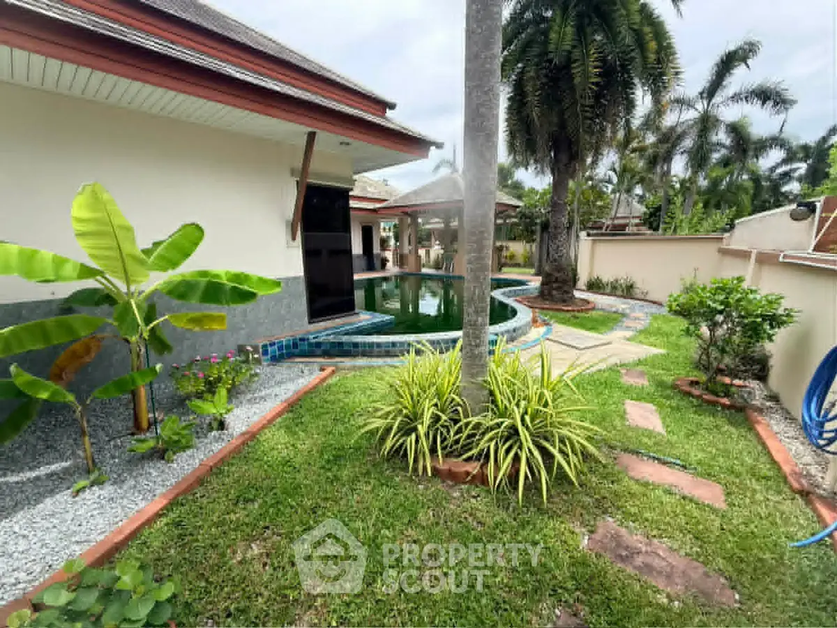 Tropical garden with pool and lush greenery in a serene residential setting.
