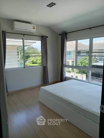 Bright bedroom with large windows and scenic view in modern home