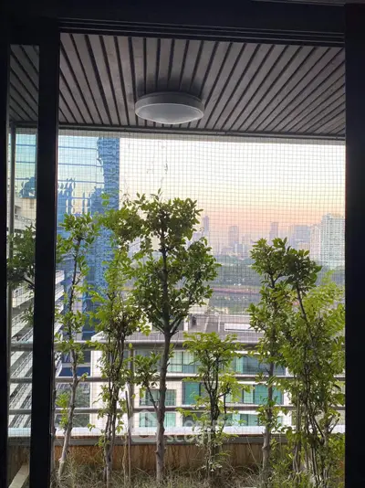 Stunning balcony view with lush greenery and cityscape backdrop, perfect for urban living.