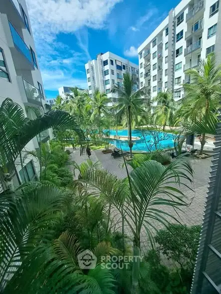 Luxurious apartment complex with lush gardens and inviting pool view.