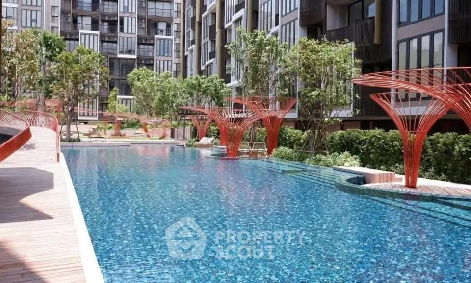 Luxurious modern apartment complex with stunning outdoor pool and lush greenery.