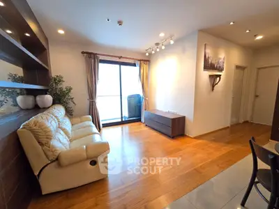 Spacious living room with wooden flooring and large window offering natural light.