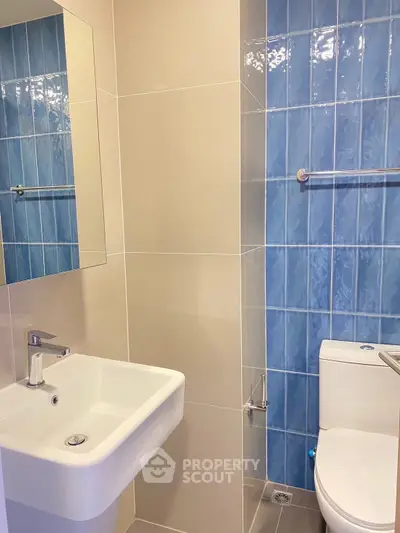 Modern bathroom with blue tile accents and sleek fixtures