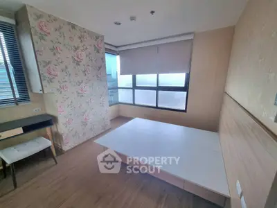 Cozy bedroom with floral accent wall and large windows offering city views