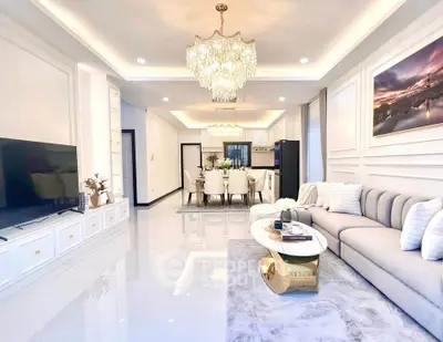 Luxurious open-plan living room with elegant chandelier and modern decor