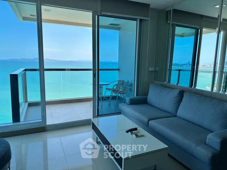 Stunning ocean view from modern living room with balcony access in luxury apartment.