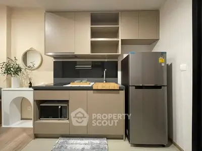 Modern kitchen with sleek cabinetry, stainless steel fridge, and built-in microwave, perfect for urban living.