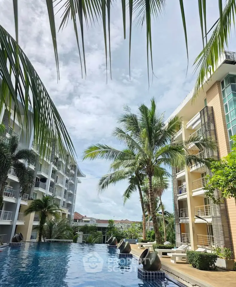 Luxurious apartment complex with stunning pool and lush palm trees, perfect for tropical living.