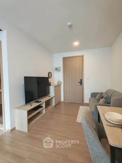 Modern living room with sleek furniture and wooden flooring in a cozy apartment.