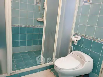 Charming blue-tiled bathroom with shower and modern toilet