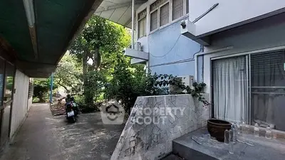 Charming residential exterior with lush greenery and private entrance