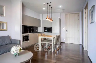 Modern open-layout kitchen and dining area with stylish lighting and sleek furniture.