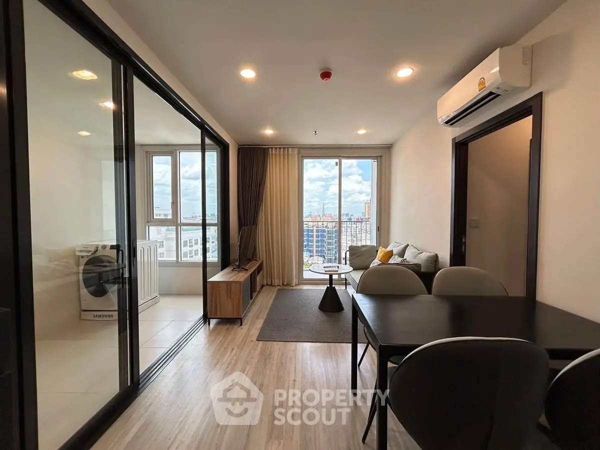 Modern living room with city view, open layout, and stylish decor in high-rise apartment.