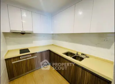 Modern kitchen with sleek cabinetry and dual sink in a corner layout
