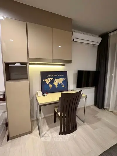 Modern study area with sleek desk, wall-mounted TV, and world map decor in stylish apartment.