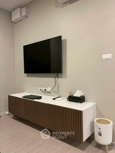 Modern living room with wall-mounted TV and sleek media console