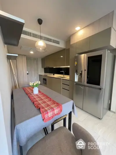 Modern kitchen with sleek cabinetry and stainless steel appliances in cozy apartment