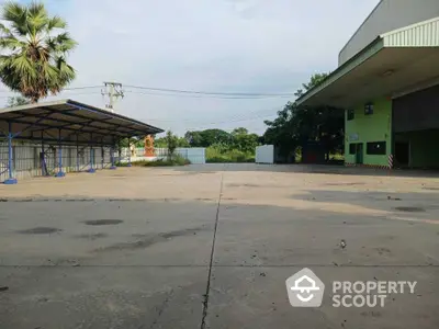 Spacious industrial property with ample outdoor space and covered parking area.