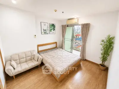 Spacious bedroom with balcony access and modern decor in a city apartment.