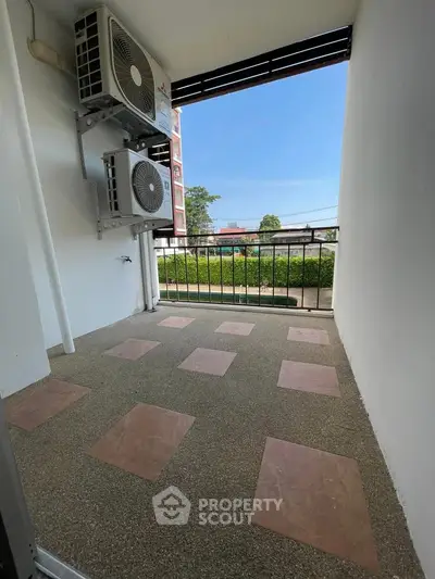 Spacious balcony with air conditioning units and scenic view, perfect for relaxation.