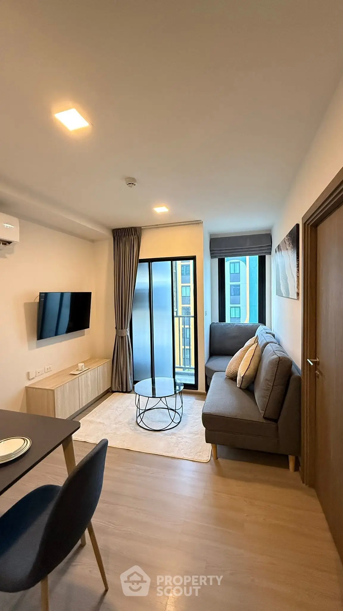 Modern living room with sleek furniture and large windows in a stylish apartment.
