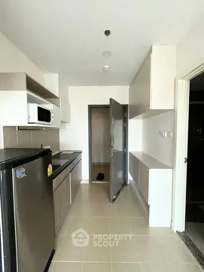 Modern kitchen with sleek cabinetry and stainless steel appliances in a contemporary apartment.