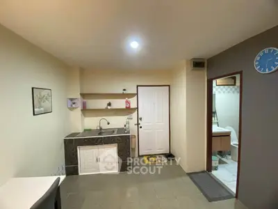 Cozy kitchen area with modern sink and adjacent bathroom in a compact apartment.
