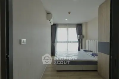 Modern bedroom with large window and stylish decor in a contemporary apartment.