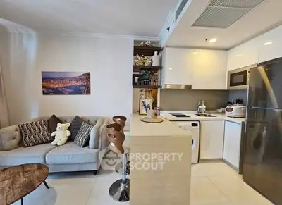 Modern open-layout kitchen and living area with stylish decor and appliances.