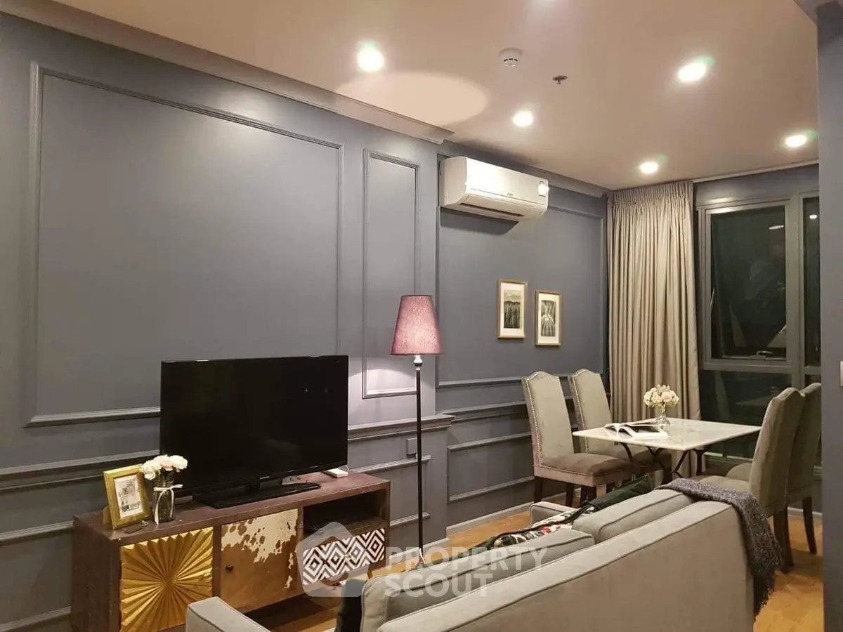 Elegant living room with modern decor, featuring a cozy dining area and stylish lighting.