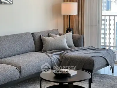 Modern living room with stylish gray sofa and elegant decor in a high-rise apartment.