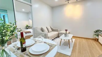 Modern living room with cozy sofa and dining area in open layout apartment.