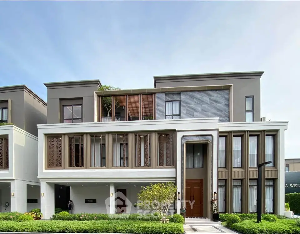 Luxurious modern townhouse with elegant facade and lush landscaping in upscale neighborhood.