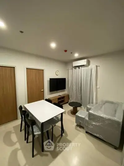 Modern living room with dining area, featuring sleek furniture and ambient lighting.