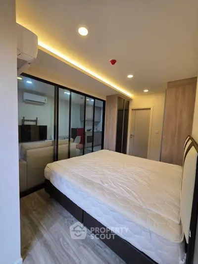 Modern bedroom with glass partition and cozy lighting in a stylish apartment.