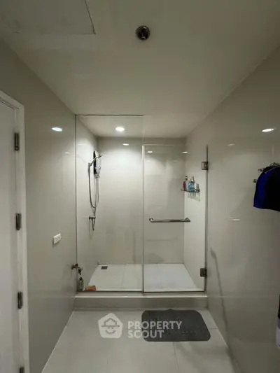 Modern bathroom with glass shower enclosure and sleek design.