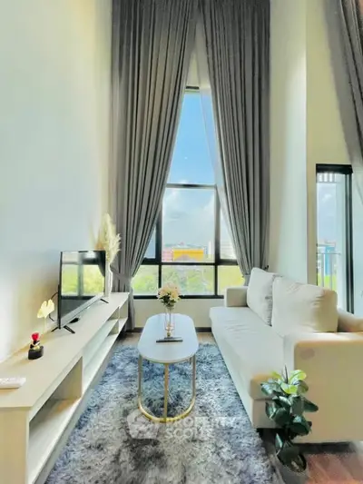Modern living room with high ceilings, large window, and elegant decor in a stylish apartment.