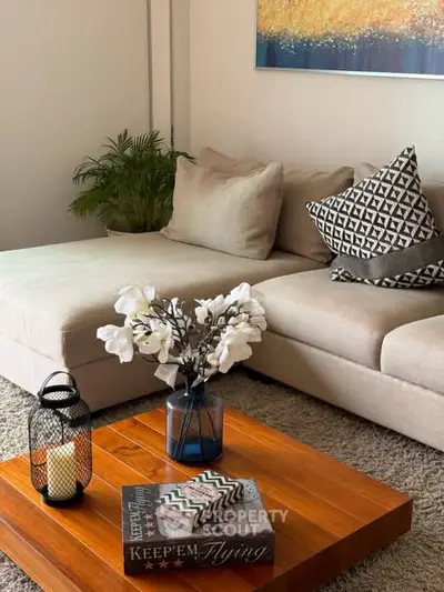 Stylish living room with cozy beige sofa, decorative pillows, and elegant wooden coffee table.