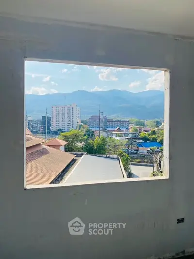 Stunning mountain view from a window in a high-rise building under construction.