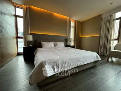 Luxurious bedroom with modern lighting and large windows in a high-rise apartment.