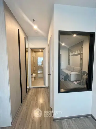 Modern apartment hallway leading to a cozy living room with stylish decor.