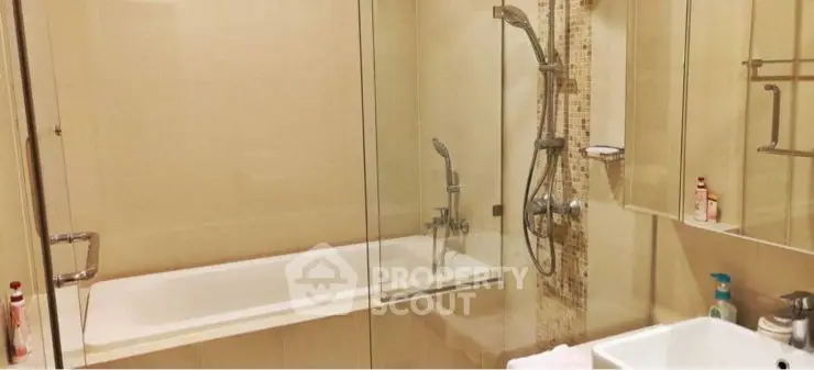 Modern bathroom with glass shower and bathtub in elegant apartment.