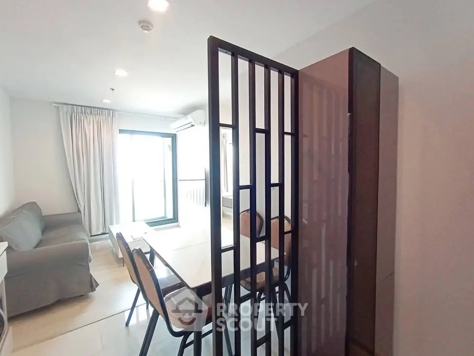 Modern living room with dining area and balcony access in a stylish apartment.