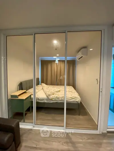 Modern bedroom with glass partition and cozy decor in urban apartment