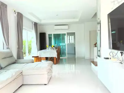 Spacious modern living room with large windows and elegant dining area
