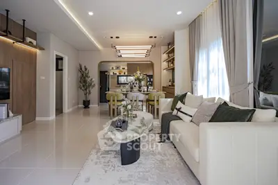 Modern living room with elegant decor and open layout, featuring a cozy sofa and stylish dining area.