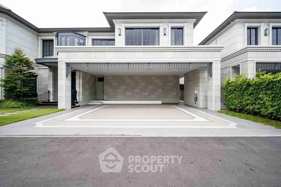 Elegant modern house with spacious driveway and lush greenery, perfect for luxury living.