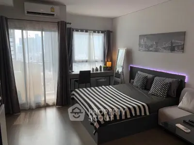 Modern bedroom with stylish decor and city view, featuring a cozy bed and work desk.