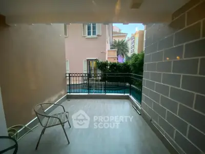 Spacious balcony with pool view in modern apartment complex