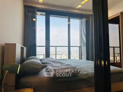 Luxurious bedroom with stunning city view and modern decor in high-rise apartment.